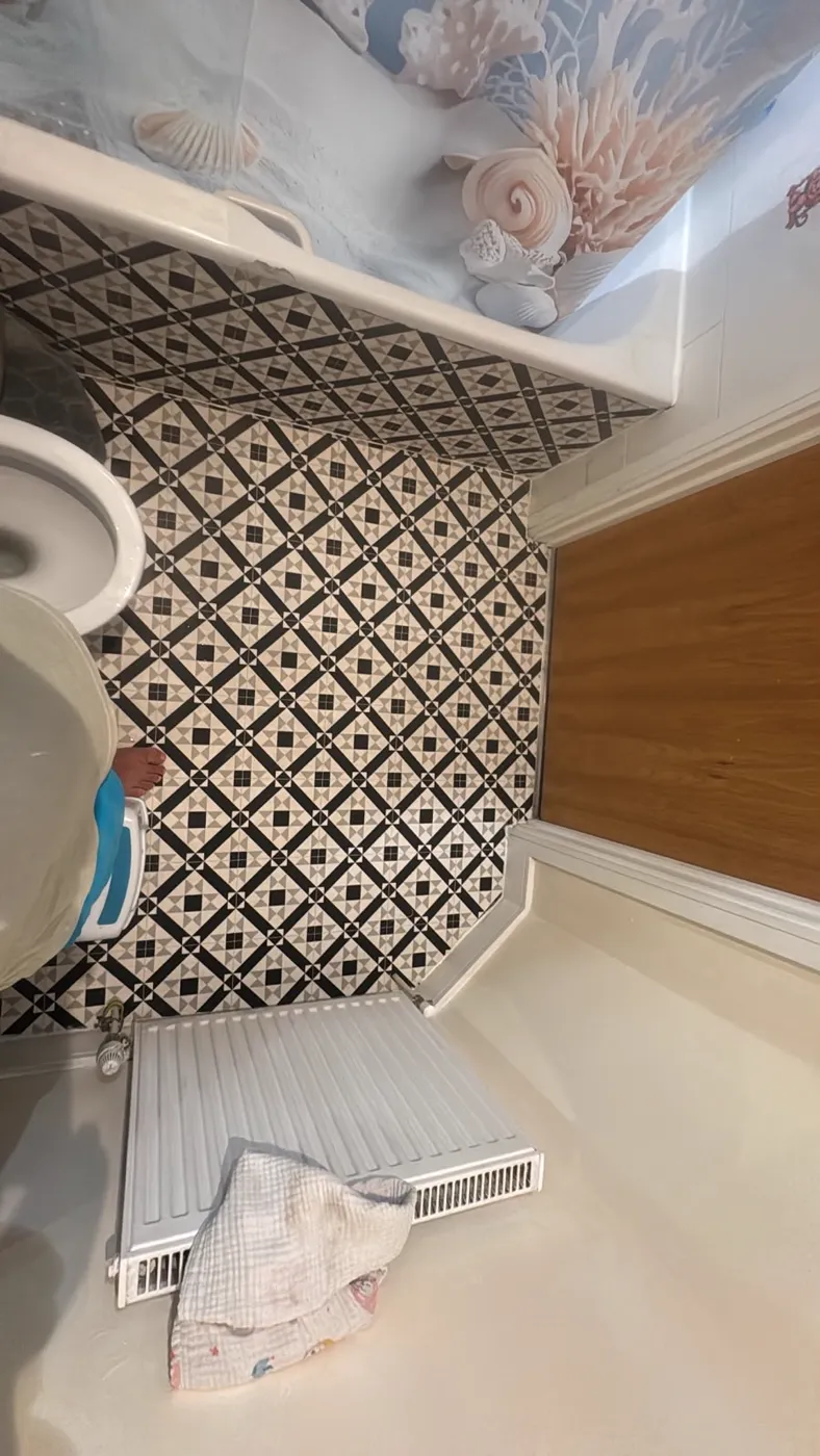 Bathroom floor tiled in a black and white pattern