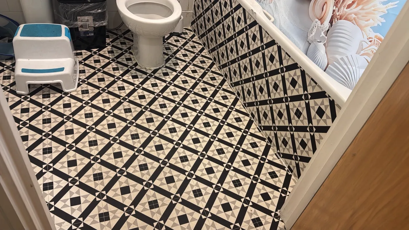 Bathroom with a black and white tiled floor